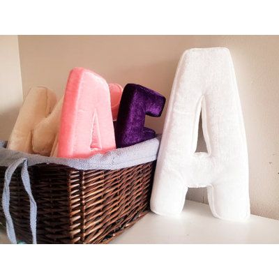 towels and bath products in a basket on a shelf next to the letter'a '