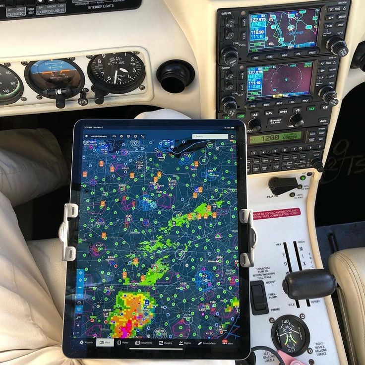 a tablet computer sitting on top of an airplane cockpit with the control panel showing flight data