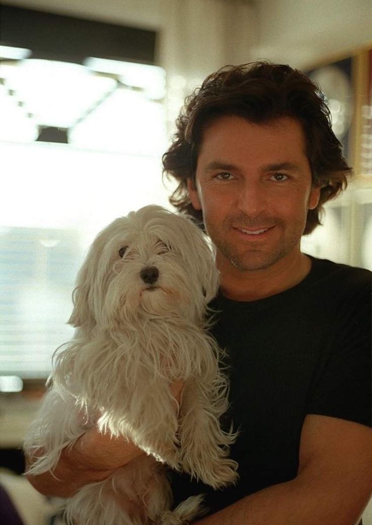 a man holding a white dog in his arms