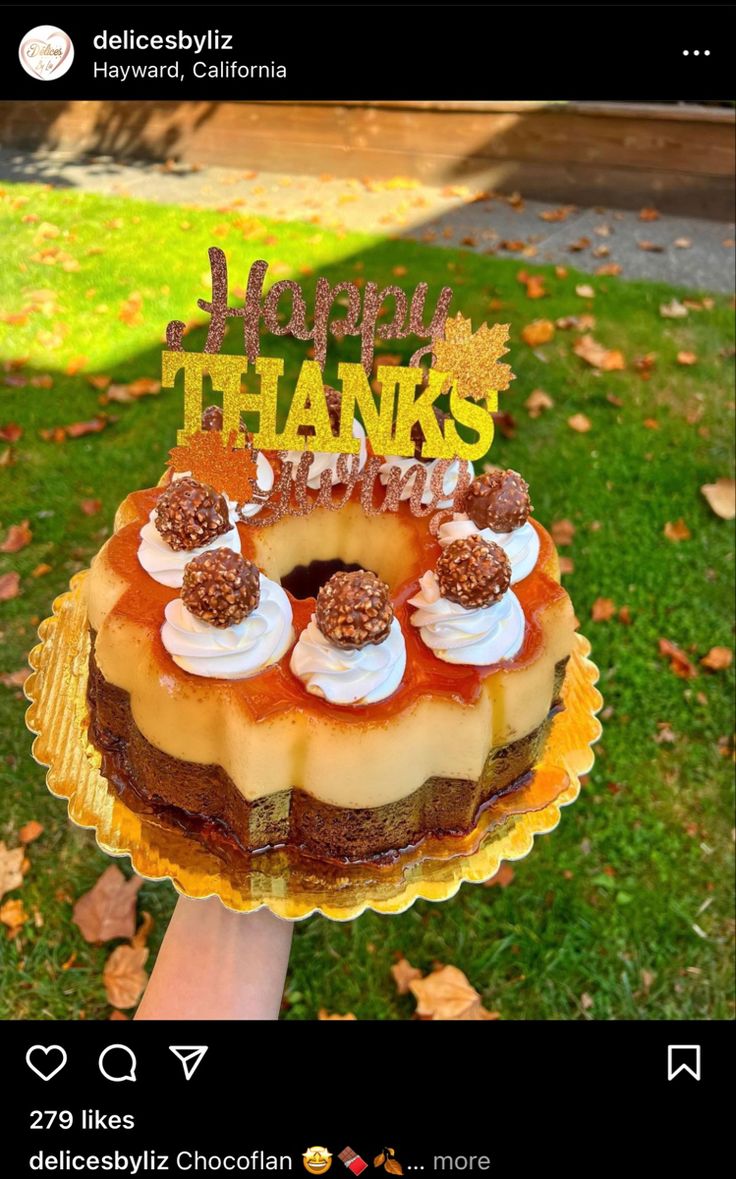 someone holding up a happy thanksgiving cake in front of the camera and it says happy thanks