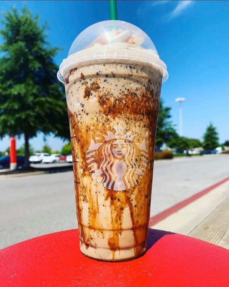 a starbucks drink sitting on top of a red table