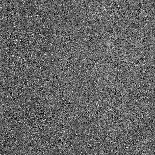 a black and white photo of the surface of an asphalt road with small speckles