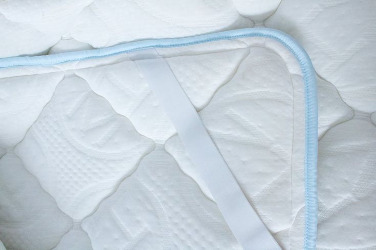 a close up view of a mattress with blue piping