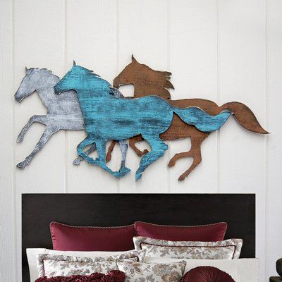 a bed with two horses on the wall above it