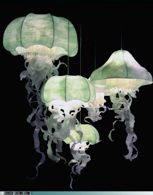 some very pretty lights that are hanging in the dark room with jellyfish on them