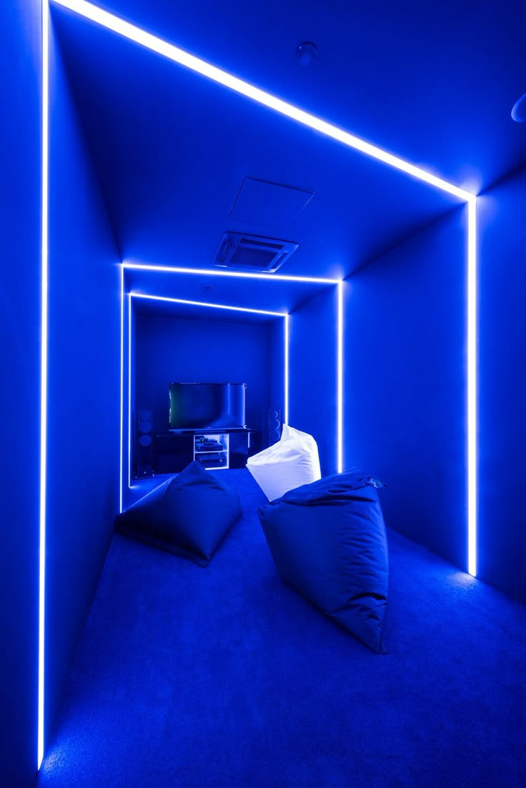 an empty room with blue lighting and two bean bags