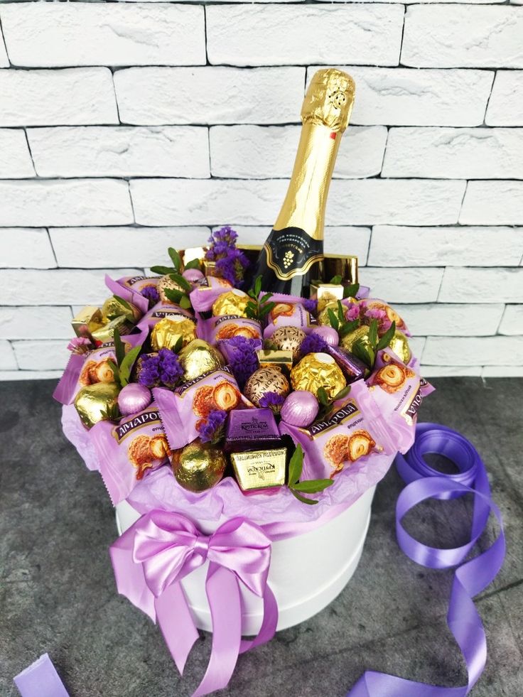 a white bucket filled with lots of chocolates and a bottle of champagne in it