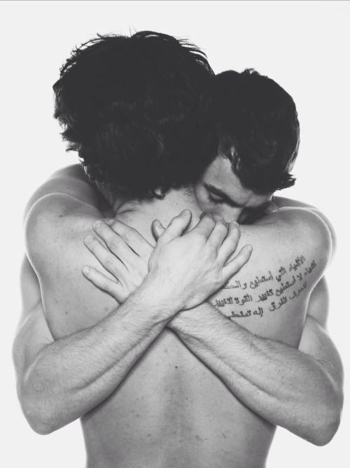 two people hugging each other with their arms wrapped around one person's chest and writing on the back