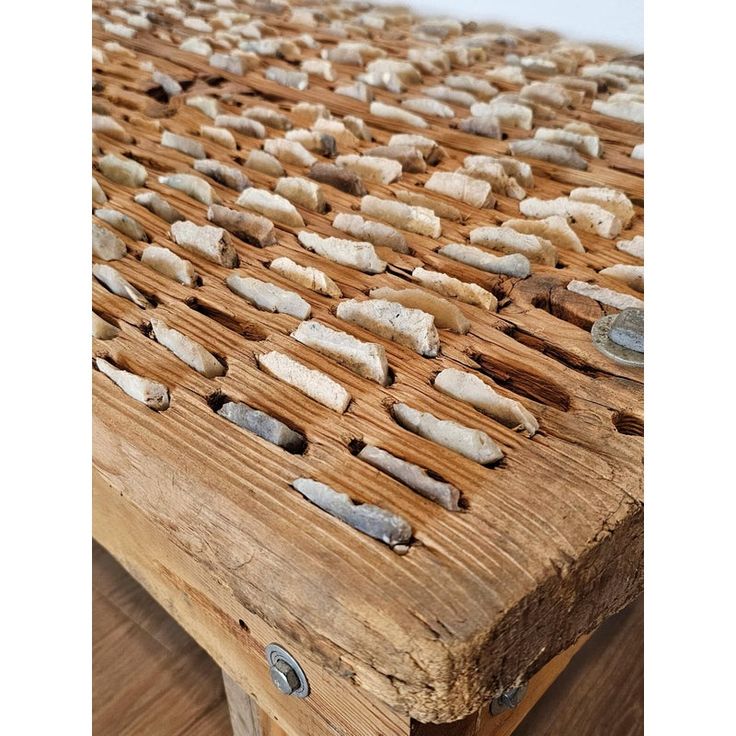 a close up of a wooden bench with nails on it