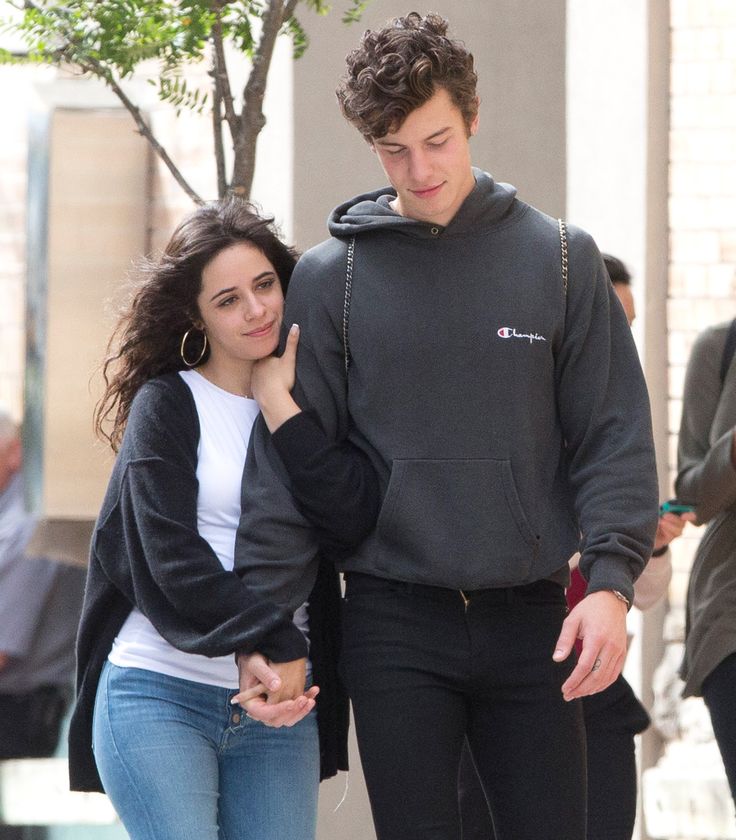 a young man and woman walking down the street