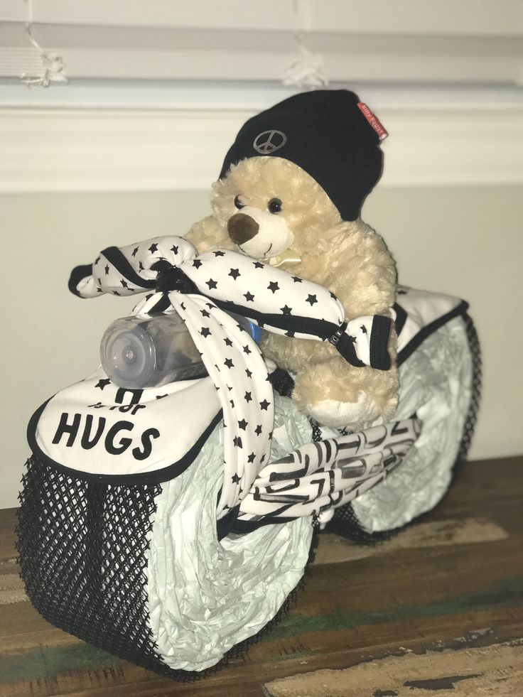 a teddy bear sitting on top of a baby stroller with a hat and scarf