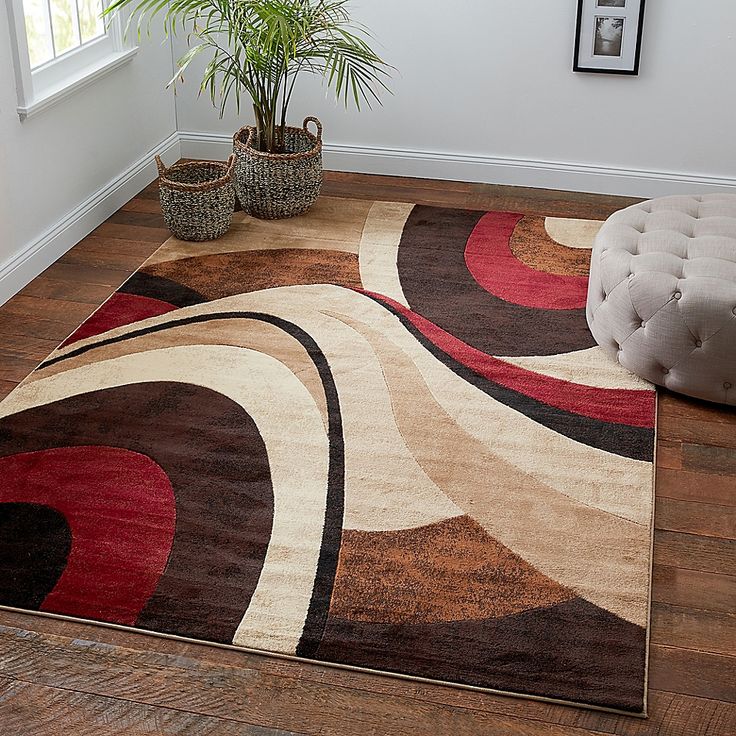 a living room area with a rug, chair and potted plant