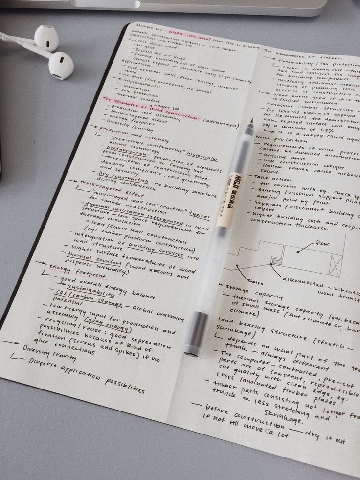 a pen sitting on top of an open book next to a computer keyboard and mouse