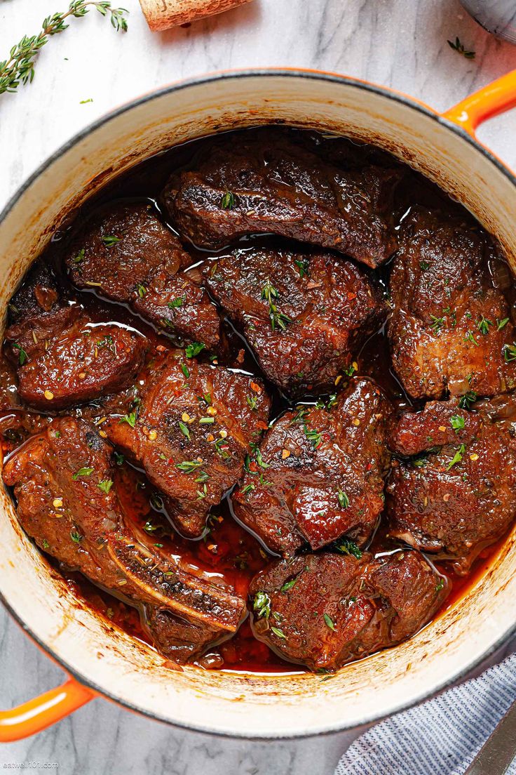 a pot filled with meat and sauce on top of a table