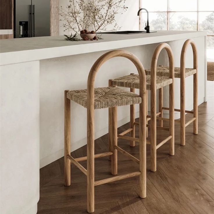 three wooden stools sitting in front of a counter