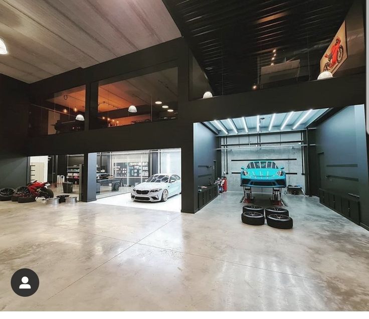 an empty garage with two cars parked in the space between it and another car on the other side