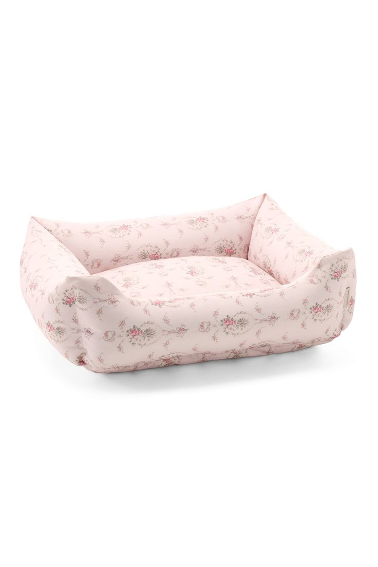 a pink dog bed with floral print on the front and bottom, it is made out of