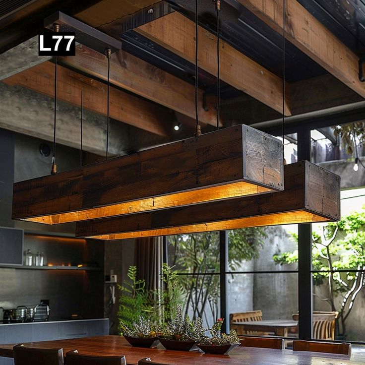 a dining room table with chairs and lights hanging from it's ceiling in front of a large window