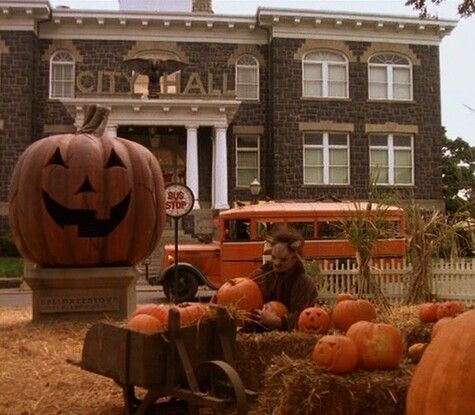 pumpkins and hay in front of an old building