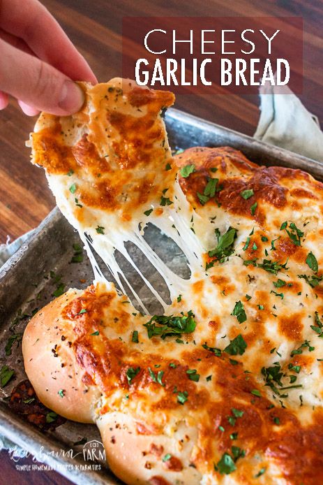 someone is taking a piece of cheesy garlic bread out of the baking pan