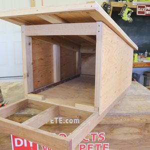 a dog house built into the side of a wooden floor in a room that is being worked on