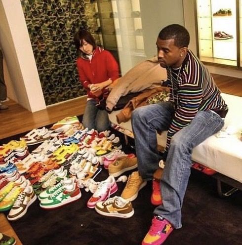 a man sitting on top of a bed covered in lots of colorful shoes next to a woman