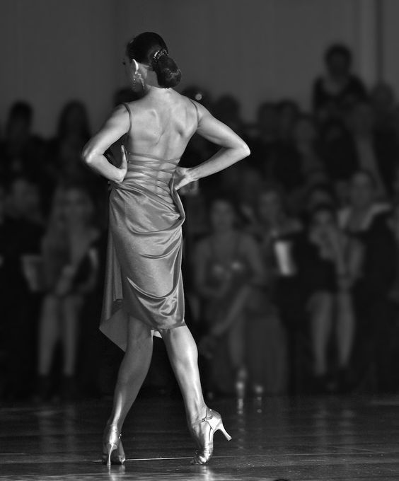 a woman is walking down the runway in a dress