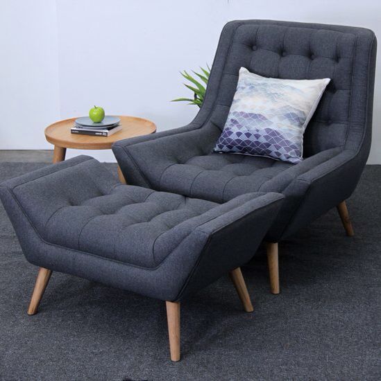 a chair and ottoman in a room with a plant on the side table next to it