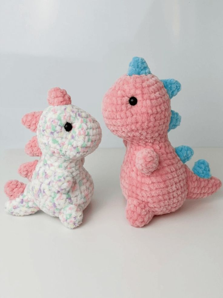 two crocheted stuffed animals sitting next to each other