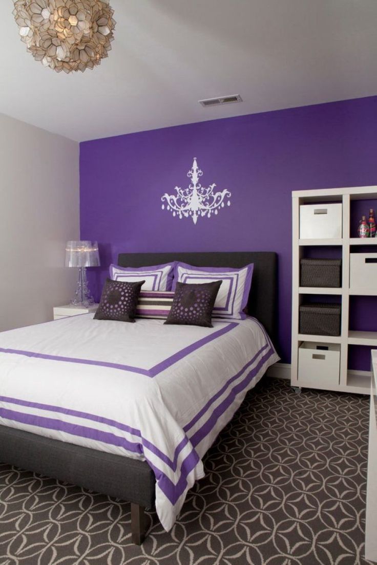 a purple and white bedroom with a chandelier