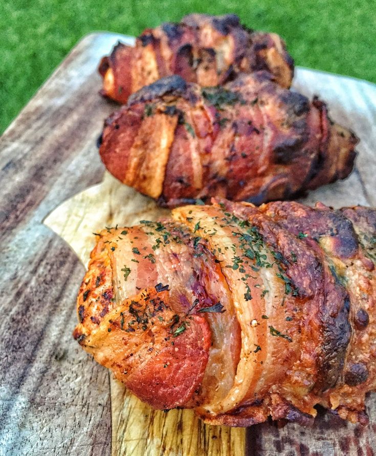 two pieces of meat sitting on top of a wooden cutting board