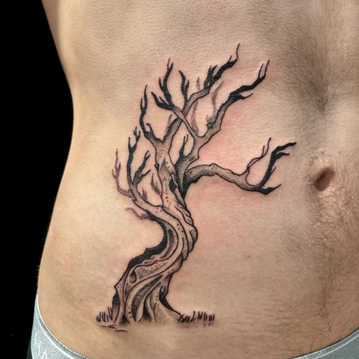 a man's stomach with a tree tattoo on it