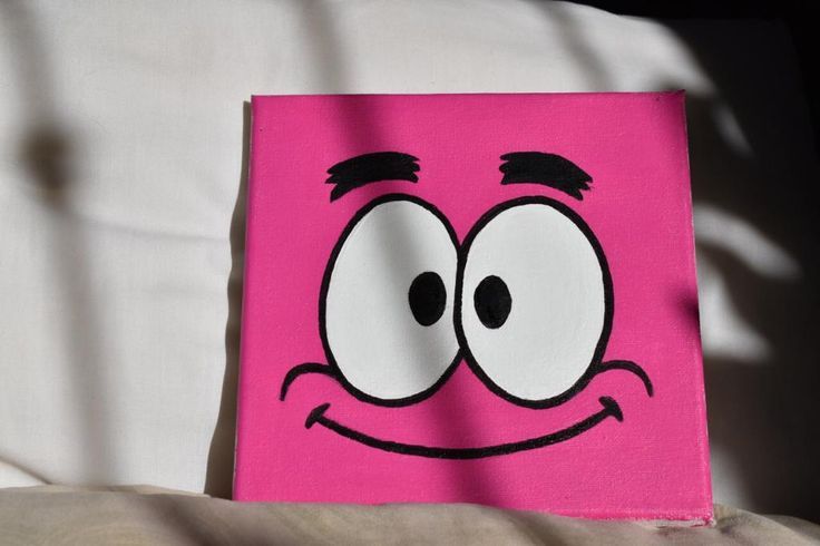 a close up of a pink square with a face drawn on it's side