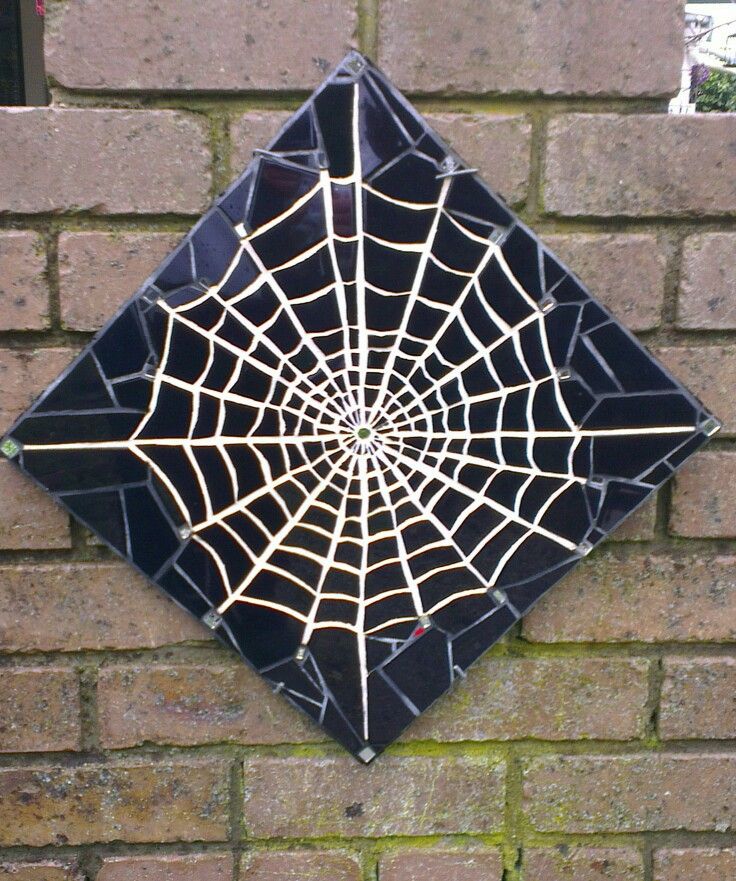 a spider web on the side of a brick wall