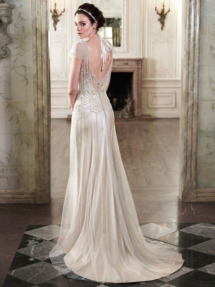 a woman in a wedding dress looking back at the camera while standing on a marble floor