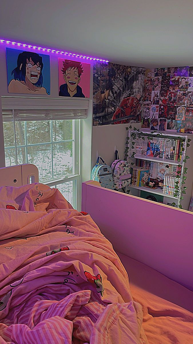 an unmade bed with pink sheets and pillows in a room with posters on the wall