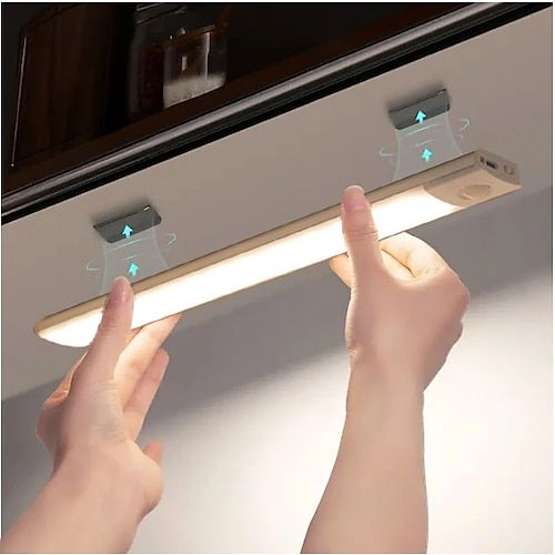 two hands are holding the light bar in front of a mirror