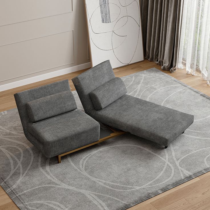 a grey couch sitting on top of a gray rug