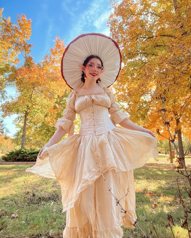 a woman dressed in an old fashioned dress and hat