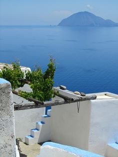 the stairs lead down to an island in the distance with blue water and greenery on either side