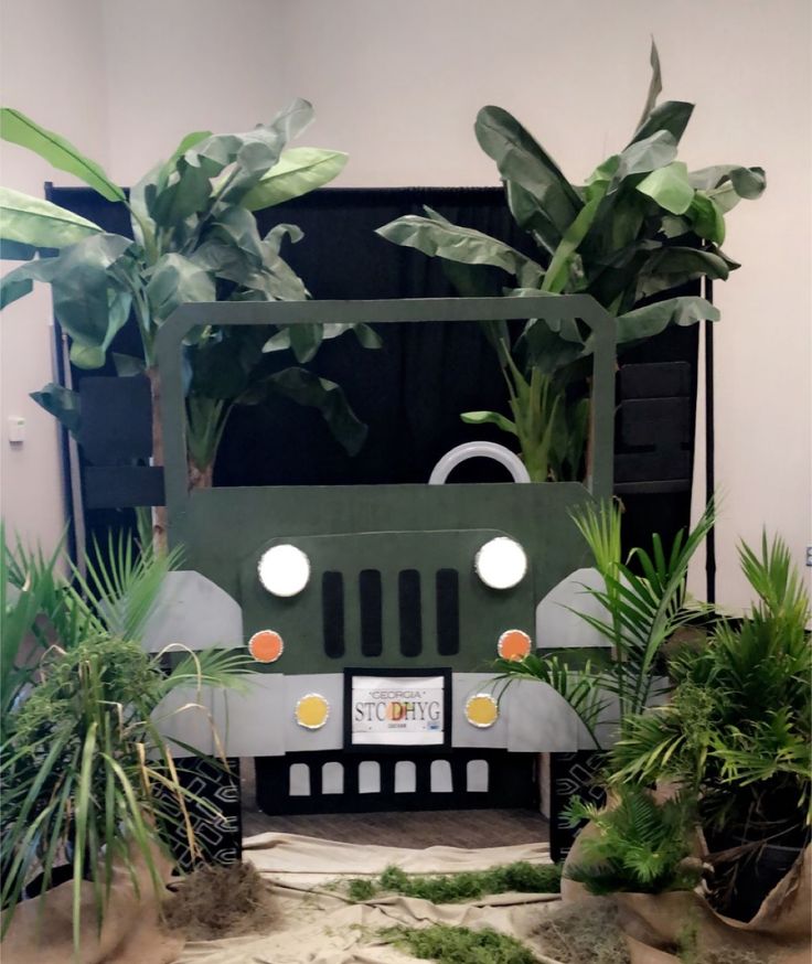 a car made out of cardboard surrounded by plants