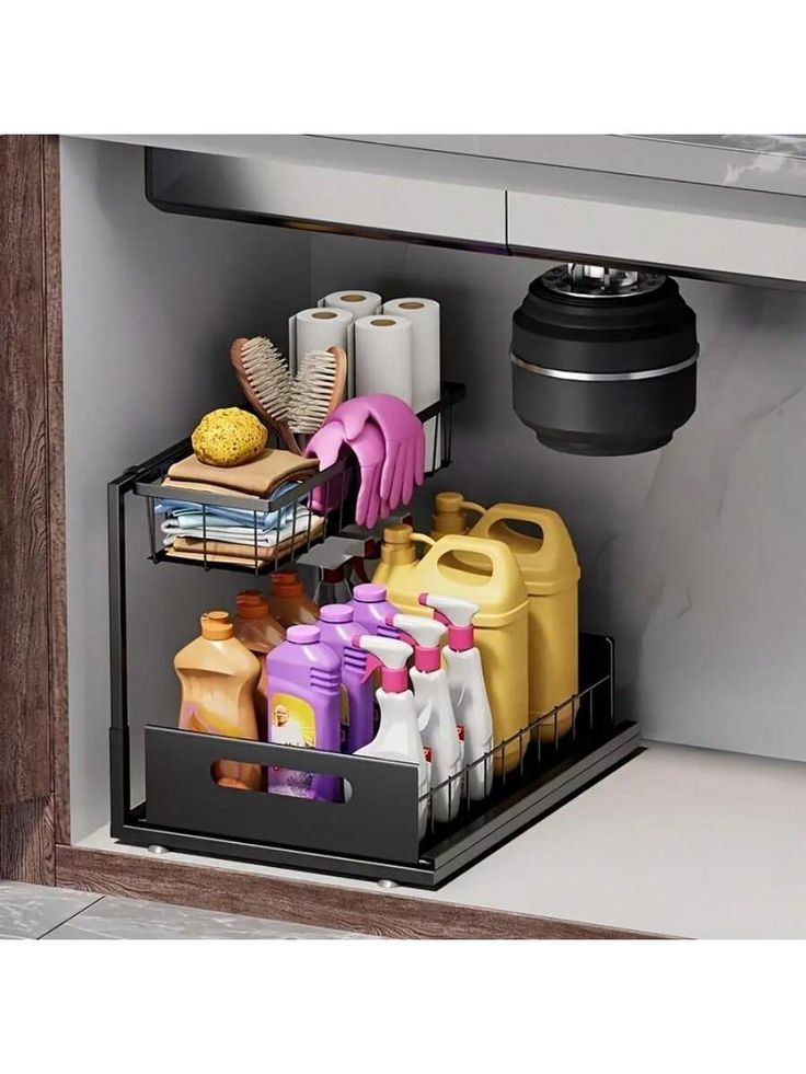 an open dishwasher door with cleaning supplies in the bottom drawer and other items inside