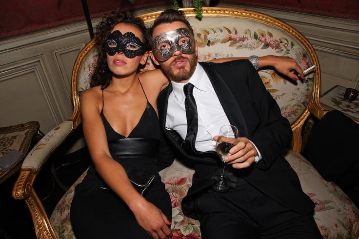 a man and woman in masquerades sitting on a couch