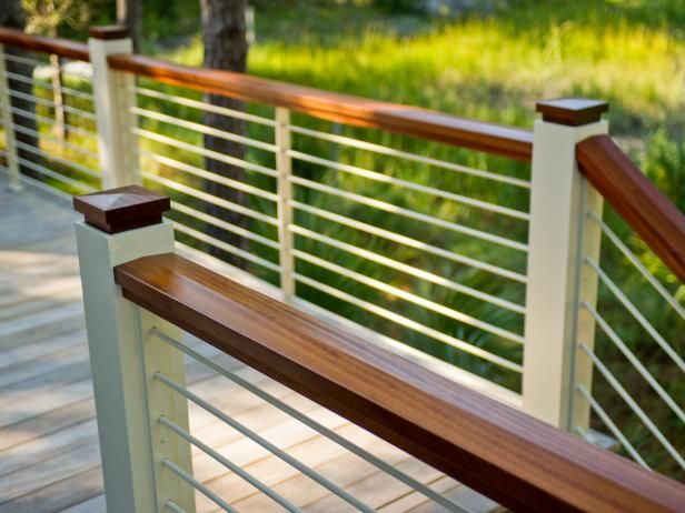 a wooden bench sitting on top of a wooden deck next to a lush green field