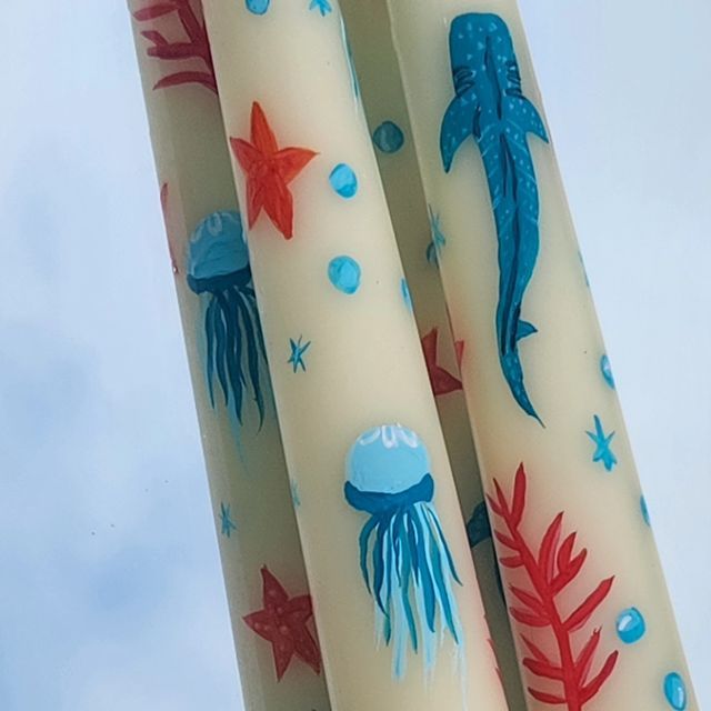 three candles decorated with sea creatures and stars