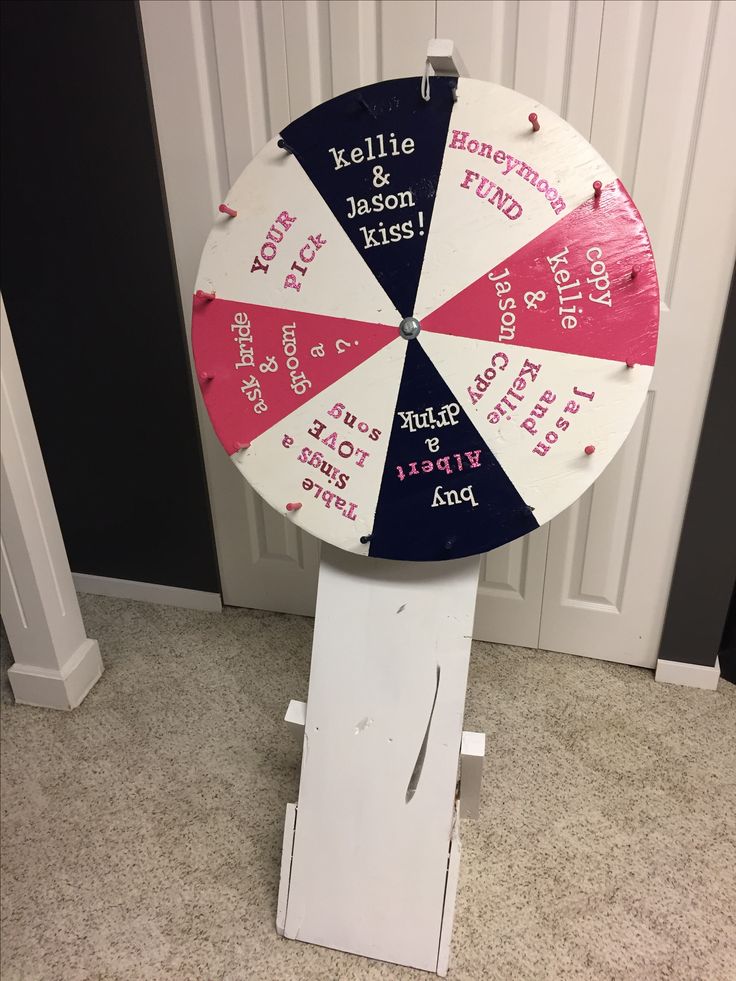 a wheel of fortune sitting on top of a white stand in front of a door