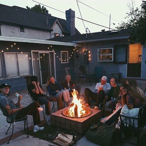 a group of people sitting around a fire pit