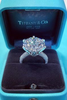 an engagement ring in a blue box with the words tiffany & co written on it