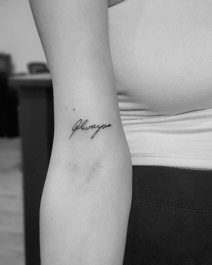 a black and white photo of a woman's arm with the word always tattooed on it