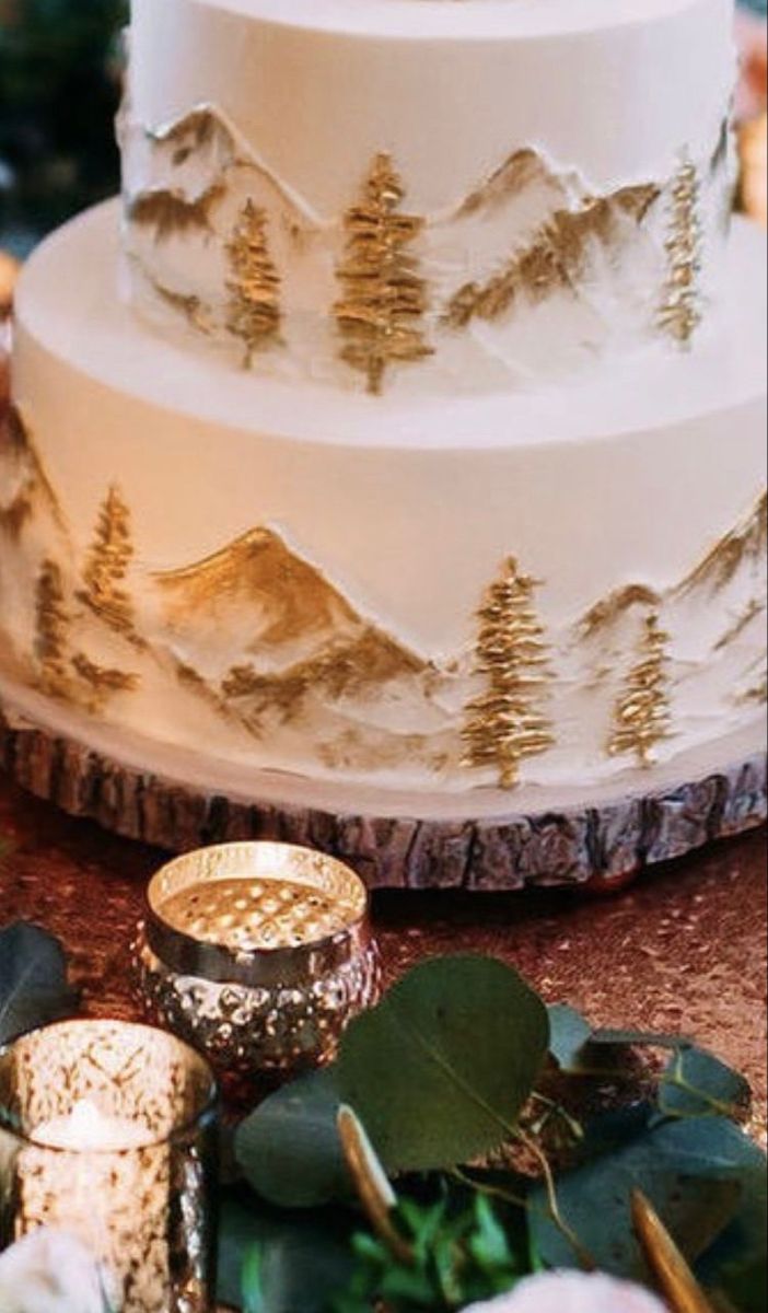 a three tiered wedding cake sitting on top of a table next to greenery